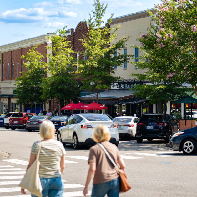 Two women at Southern Village Plaza walking towards Al's Burger Shack